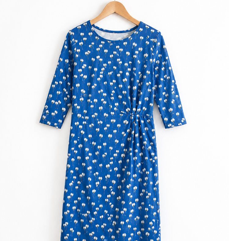 Kleid Nr. 3 aus blauem Jersey mit kleinem Muster, an einer Wand hängend