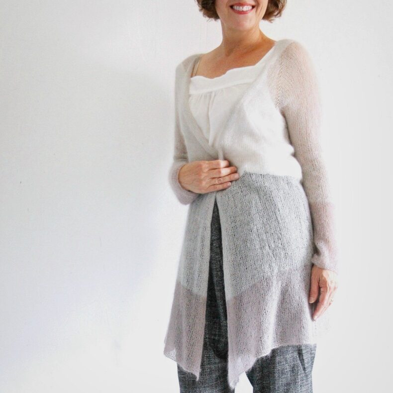 Frau trägt den Sweet Nothing Cardigan – lange, offene Strickjacke in hellem Grau ü