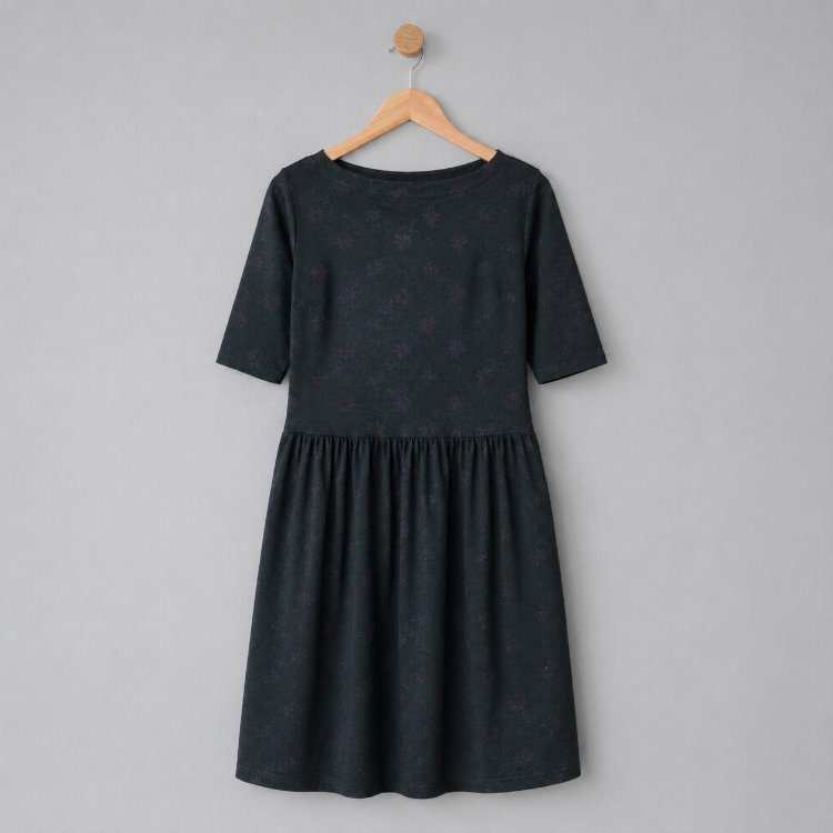 Floora Dress in schwarz vor einer hellgrauen Wand hängend