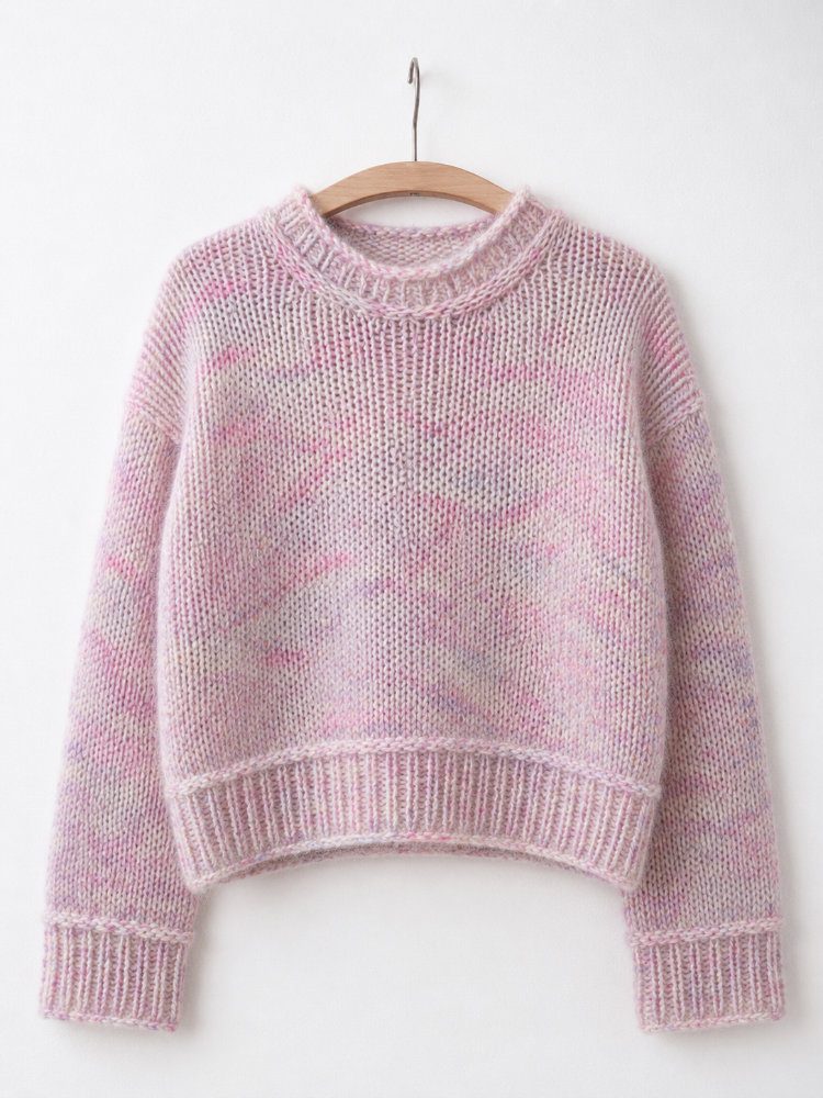 Heedi Sweater aus Merino und Mohair in zart rosa melierter Farbgebung, nahtlos von oben nach unten gestrickter Pullover mit Rundhalsausschnitt, leicht verkürzter Vorderlänge, überschnittenen Schultern und querliegenden Maschen vor den Bündchen als besonderes Designdetail.