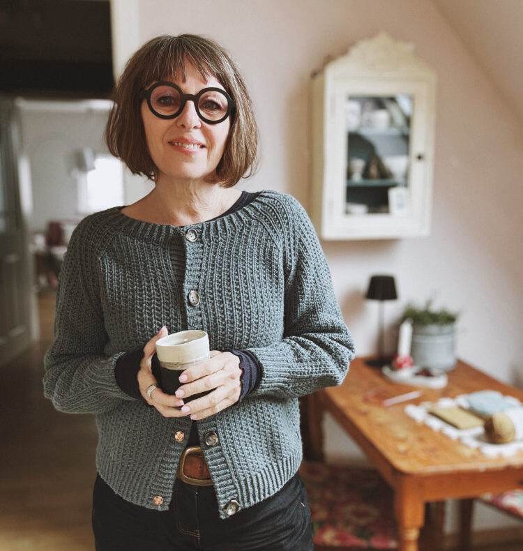 Frau trägt den gestrickten Tavalli Vest Cardigan mit Rundhalsausschnitt und Strukturmuster, rosa p. Kollektion.“