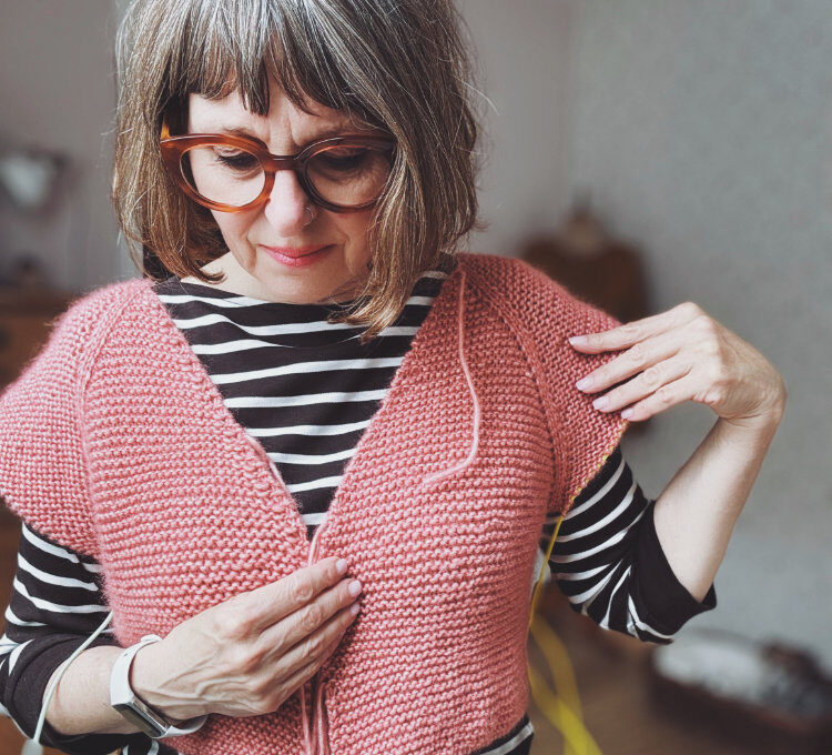 Frau strickt zeitlosen Pullover – rosa p. Strickanleitung