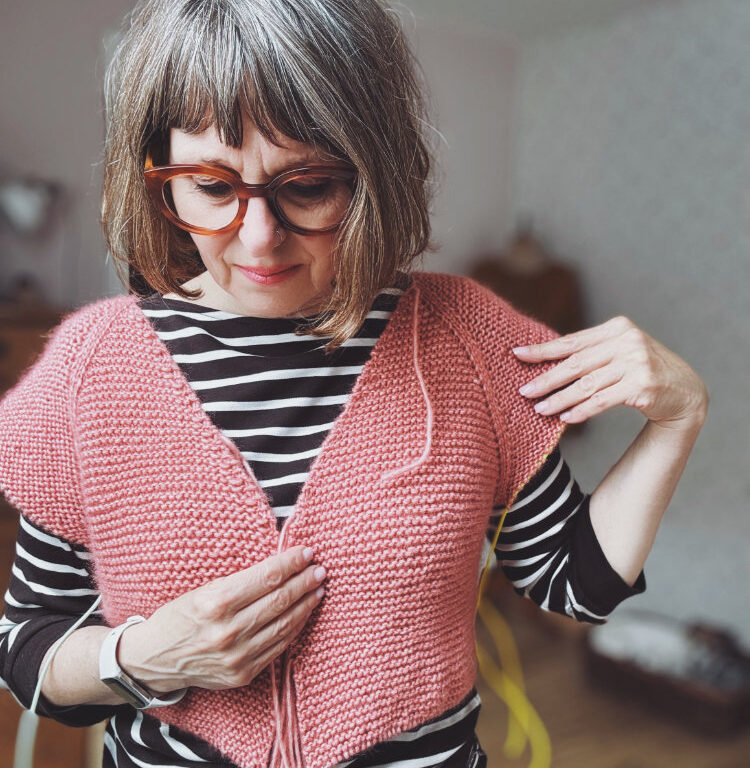 Frau strickt zeitlosen Pullover – rosa p. Strickanleitung