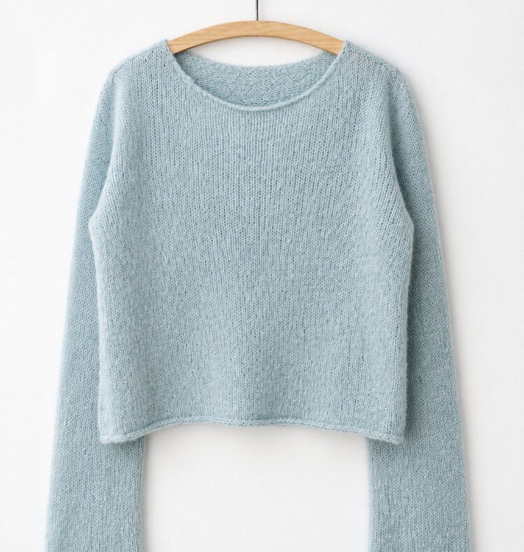 Uukii Sweater an einem Bügel vor einer weißen Wand