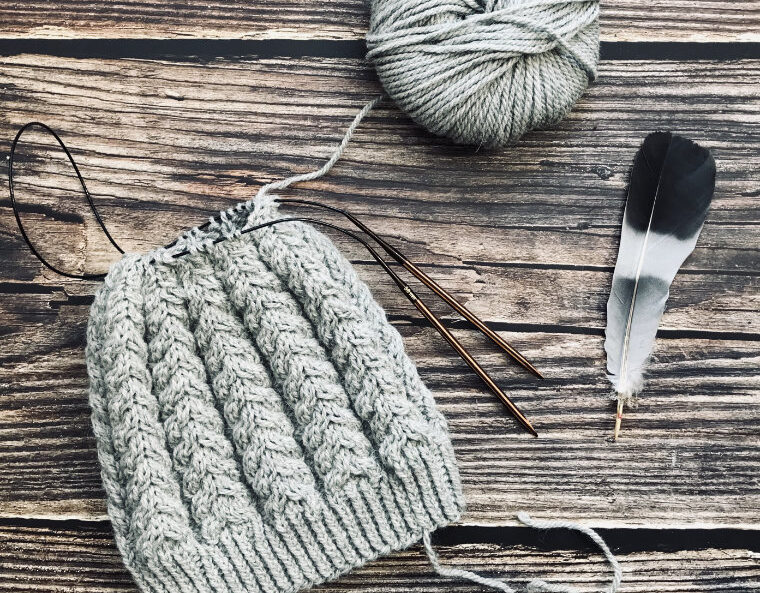 Mütze Nr. 02 – handgestrickte Wintermütze mit plastischem Zopfmuster aus der rosa p.-Kollektion, getragen im Freien; weiches Garn, klassischer Schnitt und warme, strukturierte Optik für kalte Tage. Strickideen für kalte Tage.