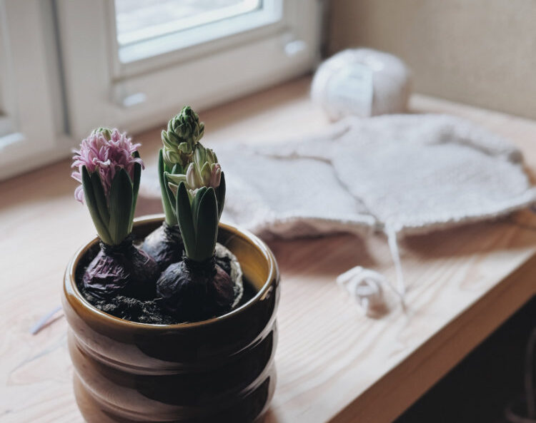 Strickplatz im Winter mit Kerze und Tasse auf dem Tisch.