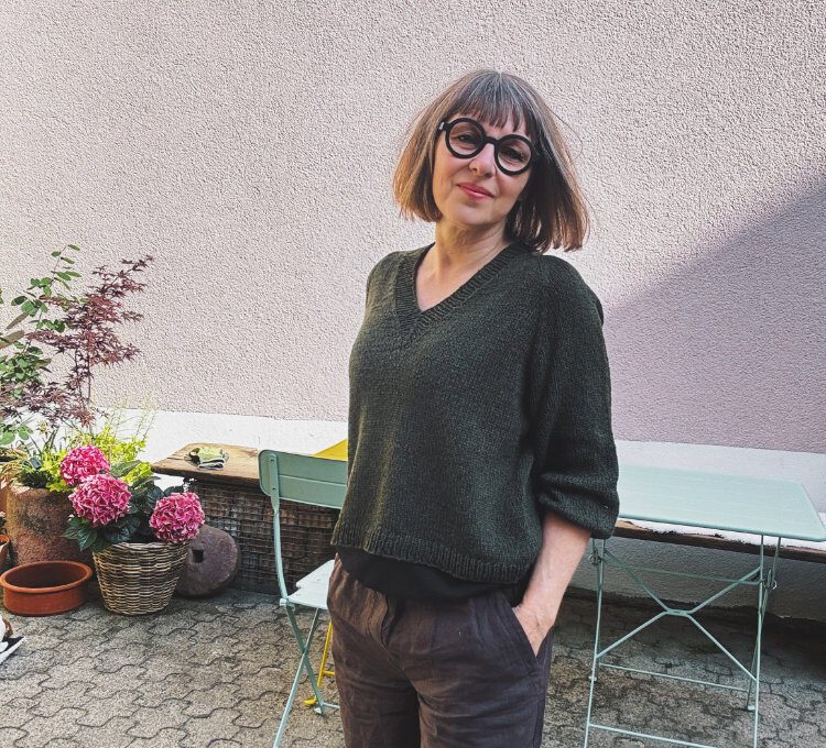 Koora Blouse Strickanleitung – nahtloser Pullover mit V-Ausschnitt aus DROPS Belle in Dunkler Wald, getragen gezeigt