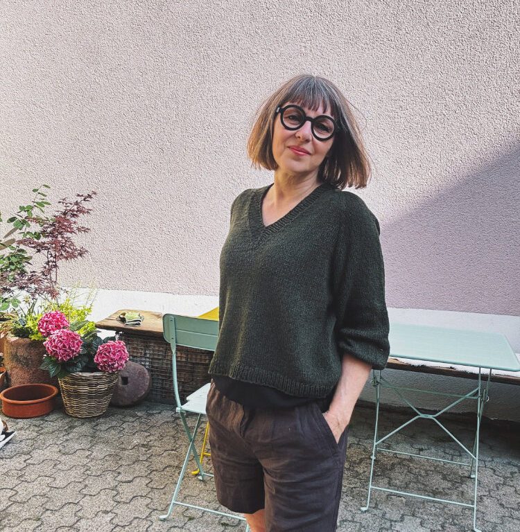 Koora Blouse Strickanleitung – nahtloser Pullover mit V-Ausschnitt aus DROPS Belle in Dunkler Wald, getragen gezeigt